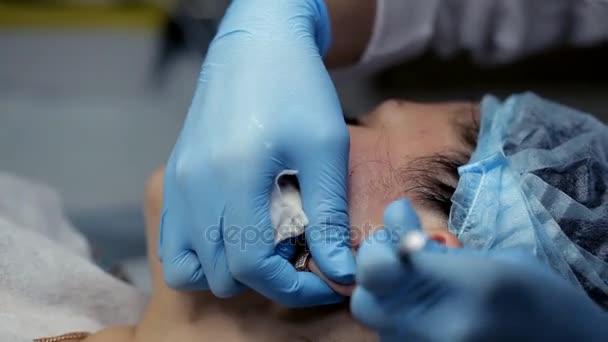 Косметолог чистит уши девочкам во время очищения лица — стоковое видео
