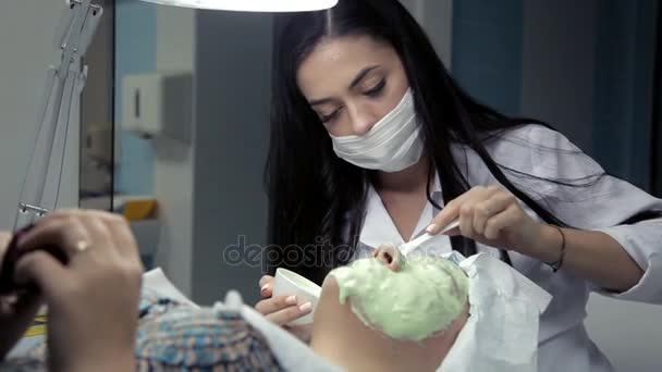 У салоні краси косметолог накладає на клієнтів маску для обличчя водоростей — стокове відео