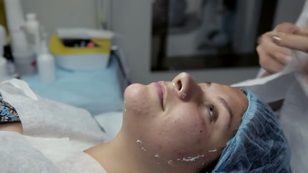 Salon kosmetyczny kosmetyczka usuwa pozostałości Alginowe uplastyczniające maski z twarzy klienta — Wideo stockowe