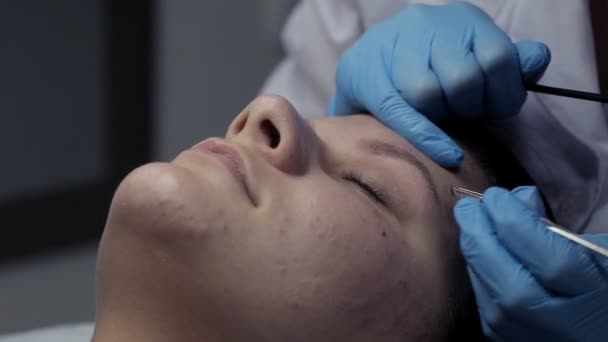 Kosmetikerin korrigiert Augenbrauen bei Klientin — Stockvideo