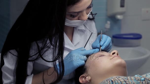 Cosmetologist makes eyebrow correction to client — Stock Video