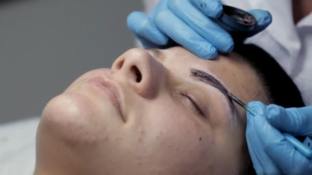 Kosmetolog fläckar ögonbryn till klienten — Stockvideo