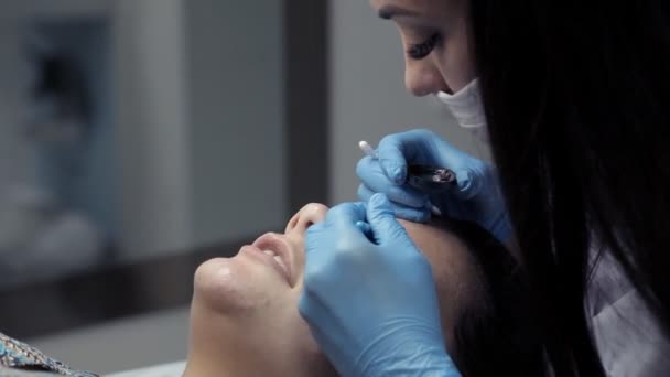 Косметолог окрашивает брови клиенту — стоковое видео