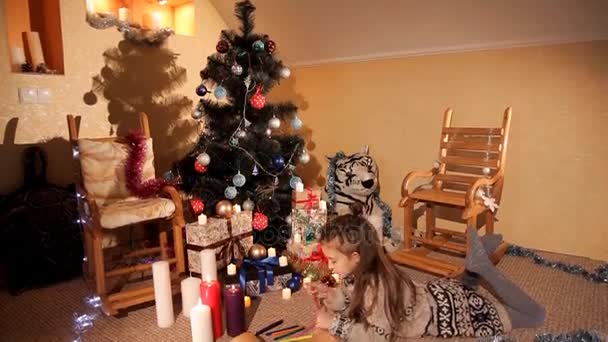 A little girl writes and draws Santa Claus a Christmas letter about her wishes for the new year — Stock Video