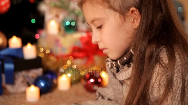 Una niña escribe y dibuja Santa Claus una carta de Navidad sobre sus deseos para el nuevo año — Vídeos de Stock