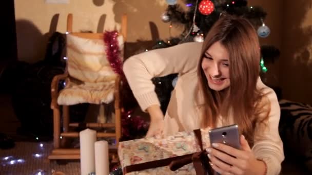 In de feestelijke New Years Eve communiceert het meisje op haar mobiele telefoon met behulp van Skype met haar familie — Stockvideo