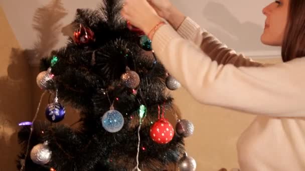 Lány díszíti a karácsonyfát — Stock videók