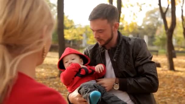 Boldog család sétál a parkban a kora ősz — Stock videók