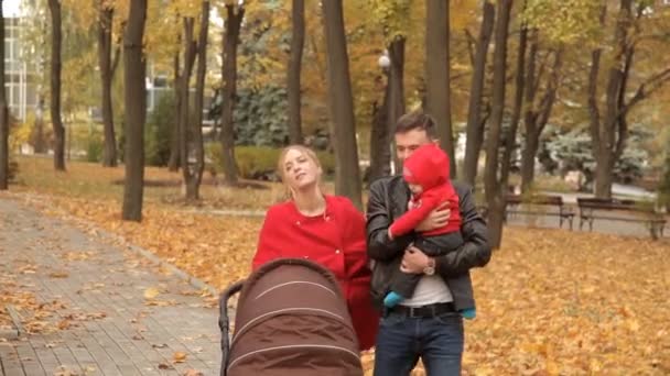 Gorgeous family strolls through the park in the early autumn — Stock Video