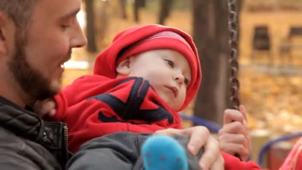 Los padres caminan con su hijo en el patio de recreo — Vídeo de stock