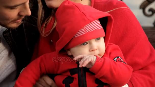 Familia feliz está descansando en un banco a lo largo del paseo marítimo — Vídeo de stock