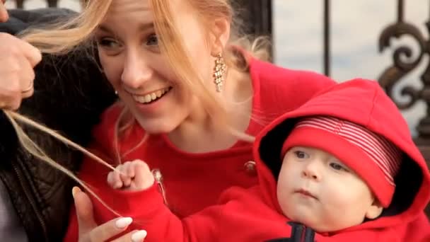 Zieht das Kind seine Mutter an den Haaren. Familienspaziergang am Wasser — Stockvideo