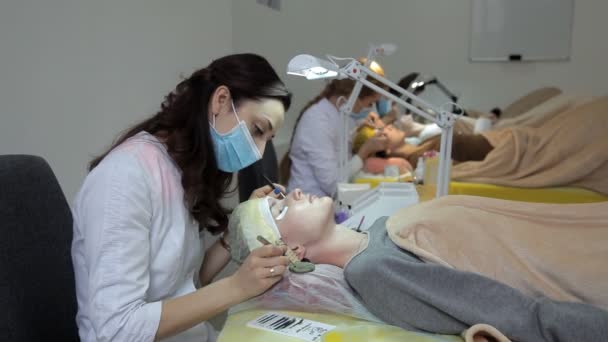 Esthéticienne fille mignonne augmente les cils. Extension des cils dans le salon de beauté — Video