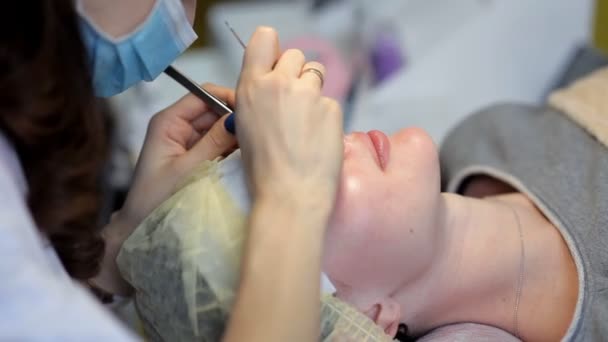 Na clínica de cosmetologia, os mestres aumentam as pestanas — Vídeo de Stock
