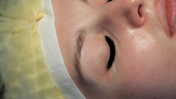 Belle fille ouvre ses yeux bleus après les extensions de cils — Video