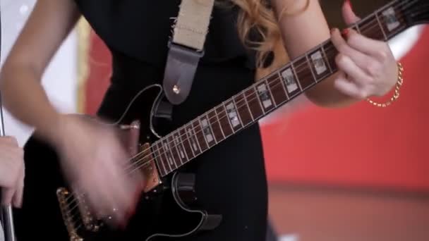 Chica en vestido negro tocando la guitarra en la fiesta — Vídeo de stock