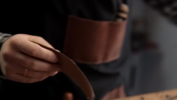 専門家は、サンドペーパーでベルトの下空白の革を処理します。革ベルト メーカー — ストック動画