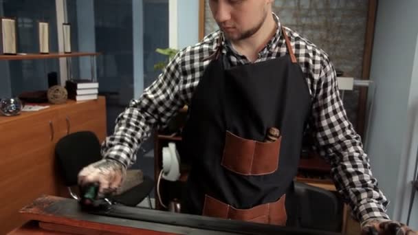 En el taller, un especialista colorea el cinturón en negro. Procedimiento para la fabricación de cinturones de cuero — Vídeo de stock