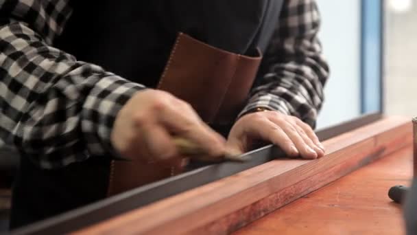 In officina, uno specialista affila una cintura di pelle. Procedura per la fabbricazione di cinture di cuoio — Video Stock