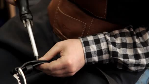 Befestigt der Meister die Schnalle am Ledergürtel. Verfahren zur Herstellung von Ledergürteln — Stockvideo