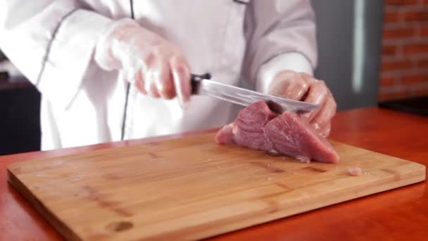 Шеф розрізає м'ясо на обробній дошці — стокове відео