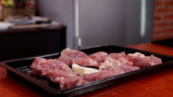 Шеф-повар солит нарезанное мясо на хлебопекарном листе — стоковое видео