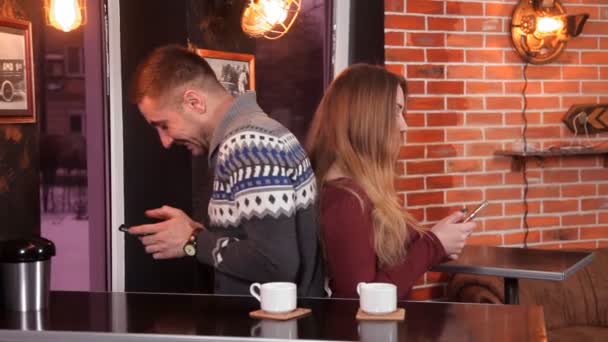 Aimer couple boire du café dans le restaurant et utiliser des smartphones — Video