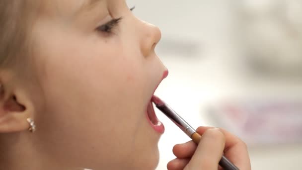 Meisje-dametje schildert lippen met lippenstift — Stockvideo