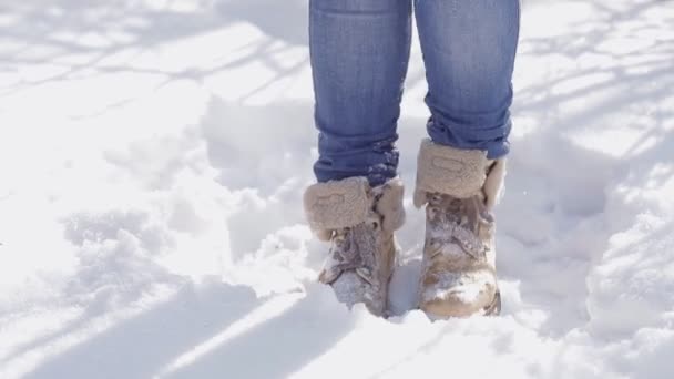 La ragazza scrollati di dosso la neve dalle scarpe, pur rimanendo in esso — Video Stock