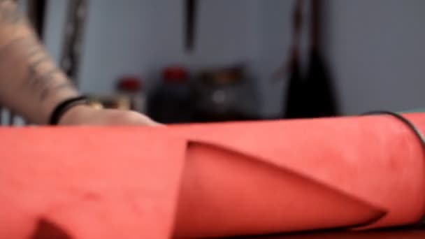Mester lecsavarható egy tekercs piros bőr bőr áruk gyártásához — Stock videók
