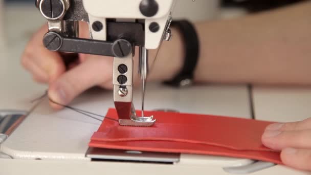 Na oficina, um homem costura couro real com uma máquina de costura. Procedimento para o fabrico de produtos de couro — Vídeo de Stock