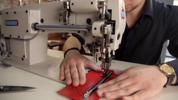 ワーク ショップでは、男は本物の革をミシンで縫います。皮革製品の製造のための手順 — ストック動画