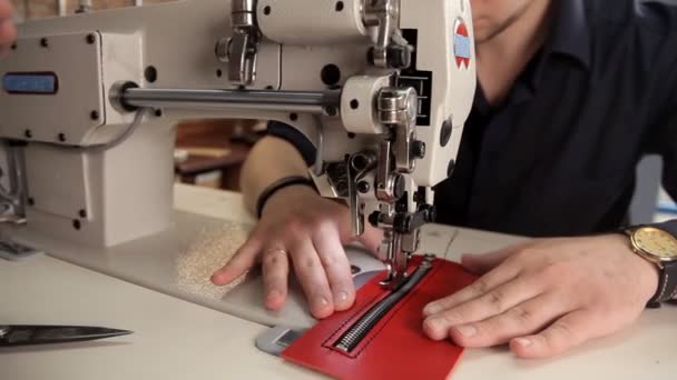 I verkstaden syr en man äkta läder med en symaskin. Förfarande för tillverkning av lädervaror — Stockvideo