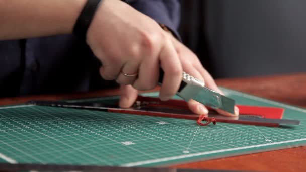 In officina, un uomo incolla i pezzi della pelle, facendo un portafoglio — Video Stock