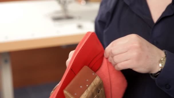 Man met zijn handen maakt een lederen portemonnee. Een man van lederen portemonnee-lederen product stiksels — Stockvideo