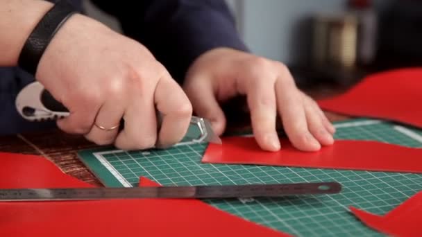 Craftsman with an industrial knife and ruler cut blank skin of leather cloth — Stock Video