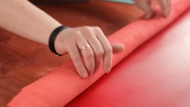 Artesano convierte tela de cuero rojo en un rollo — Vídeos de Stock