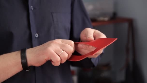 Handwerker mit Feuerzeug beseitigt Unebenheiten am Lederprodukt — Stockvideo