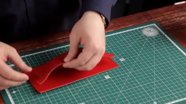 The artisan in the workshop glues the leather blanks, making the leather product — Stock Video