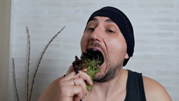 Primer plano hombre con una rebanada de verduras en la boca, concepto de estilo de vida vegano — Vídeo de stock