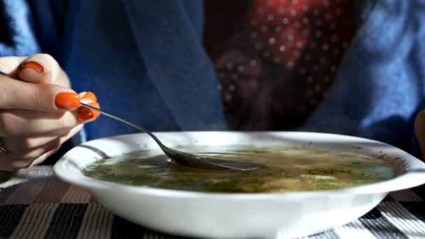 Les mains féminines tiennent une cuillère dans une soupe de nouilles de poulet bouillon. Soupe de poulet traditionnelle servie dans un bol — Video