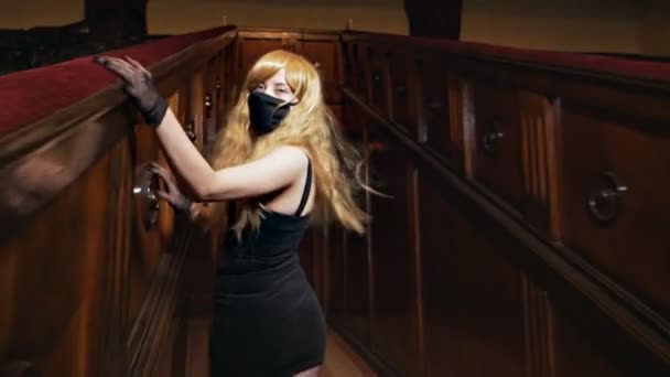 Gemaskerd jong blond beweegt en poseert seksueel in een concertzaal — Stockvideo