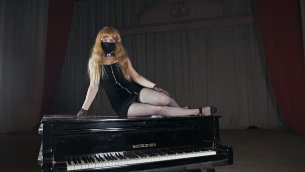 Güzel kız piyanonun üzerine uzanır. Seksi elbiseli çekici bir kadın. Seksi kadın piyanist. — Stok video