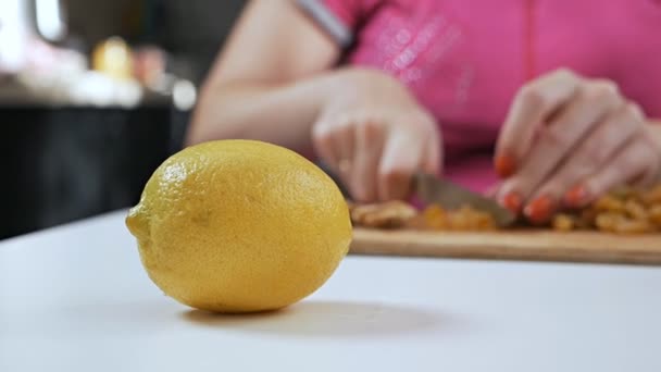 Una joven ama de casa corta fruta seca con un cuchillo en una tabla de cortar. Concepto de alimentación saludable — Vídeo de stock