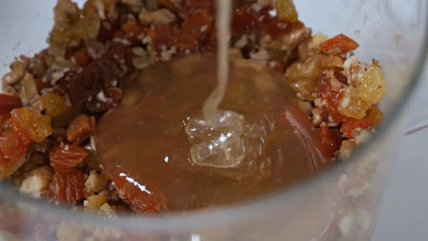 Granola maison avec flocons d'avoine, cassonade, noix et fruits secs dans un bocal, le miel est versé dans le granola — Video