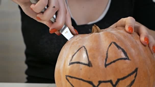 Calabaza naranja tallada para celebrar la tradición de Halloween con las manos de mujer. Preparando el paisaje para una tradicional fiesta de otoño — Vídeos de Stock