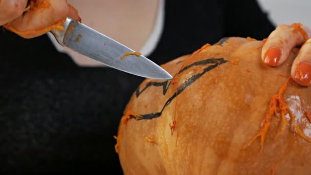 Mulher esculpe de uma abóbora Jack-o-lanterna para a celebração de Halloween — Vídeo de Stock