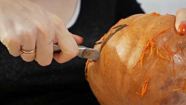 Kvinna skär från en pumpa Jack-o-lantern för Halloweenfirande — Stockvideo