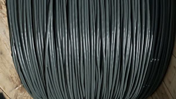 Primer plano de un cable de alimentación en un carrete de madera grande. Productos terminados planta de cable — Vídeo de stock