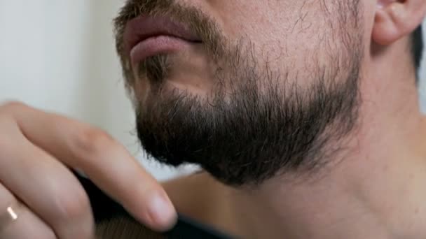 护肤的概念。 一个留着胡子或没有刮胡子的男人在镜子前注意自己的外表 — 图库视频影像